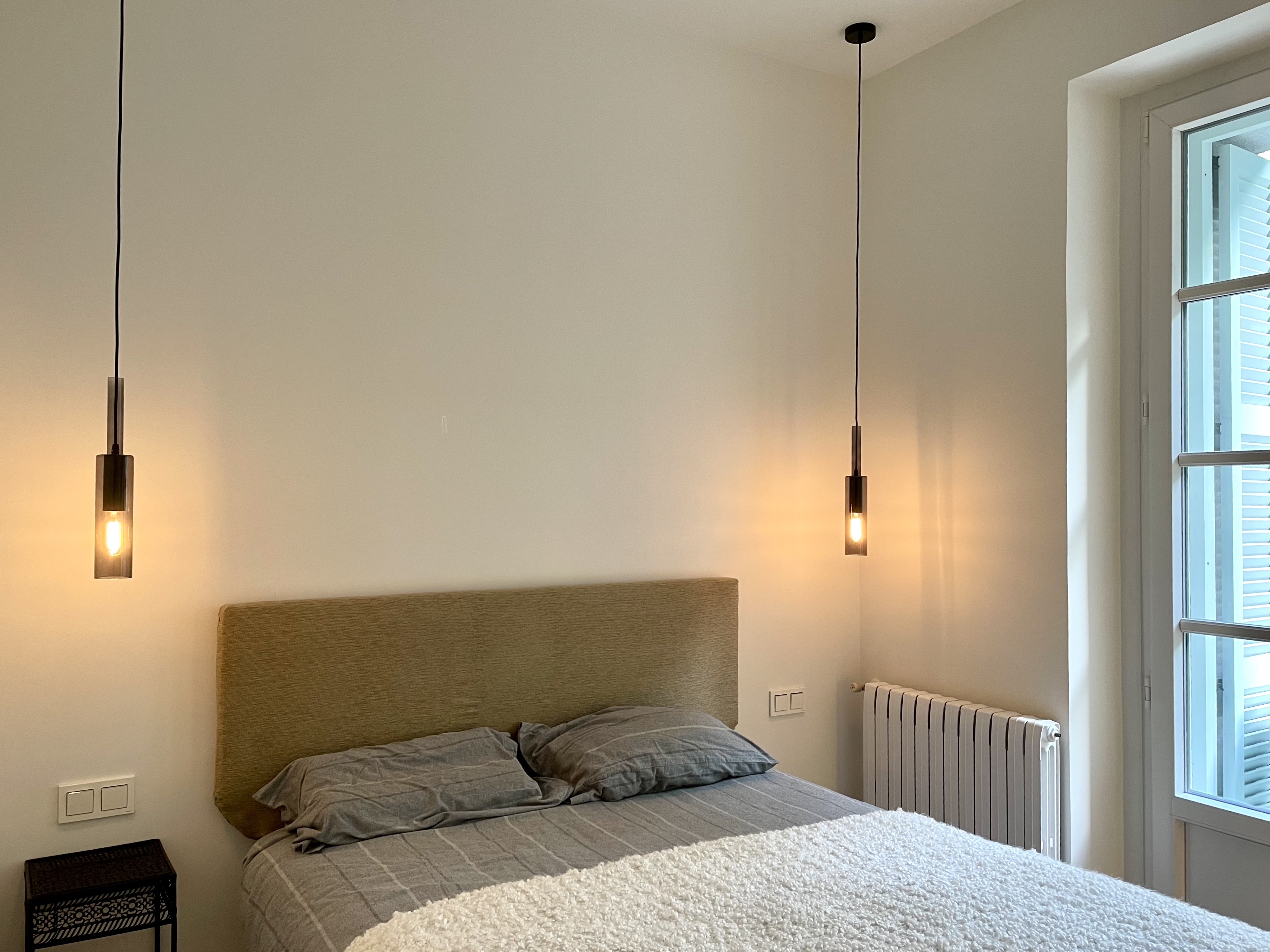Decoración en dormitorio, lamparas de mesilla colgando del techo en Donostia - San Sebastian.