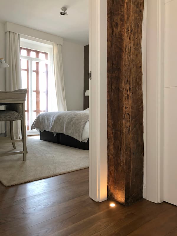 Entrada a uno de los dormitorios. Iluminacion led de baja intensidad iluminanda la entrada de la habiatación suavemente integrada en el suelo de madera.